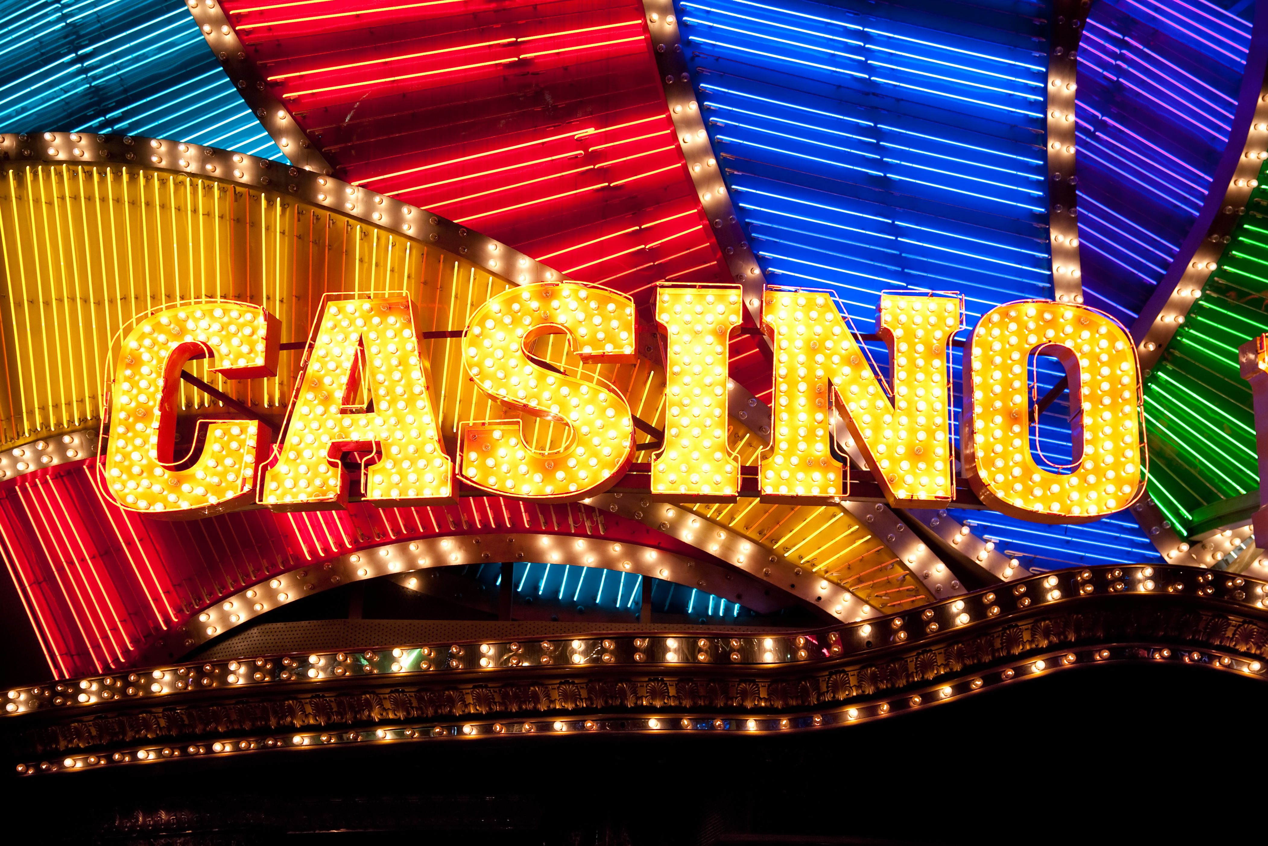 A vibrant graphic showcasing the Infinity Slots logo with a cascade of gold coins and puzzle pieces.